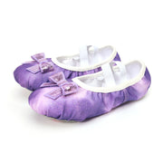 Purple baby shoes with white soles and decorative bows on a white background