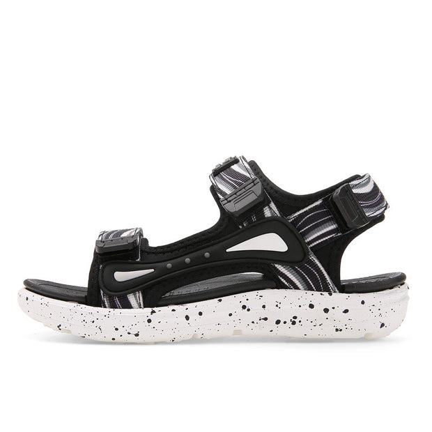 Black and white sandal with speckled sole on a white background