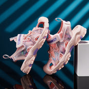 Pair of pink and purple sneakers on a reflective surface with a blue striped background