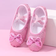 Pink glittery ballet shoes with bows on a pink background